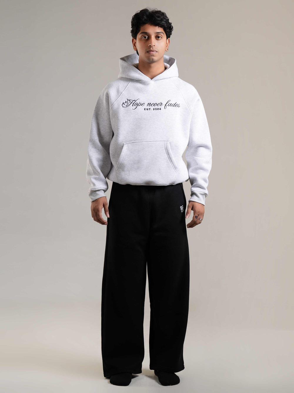 Person wearing a white hoodie with 'Endless hope' text on the back, standing against a plain background.