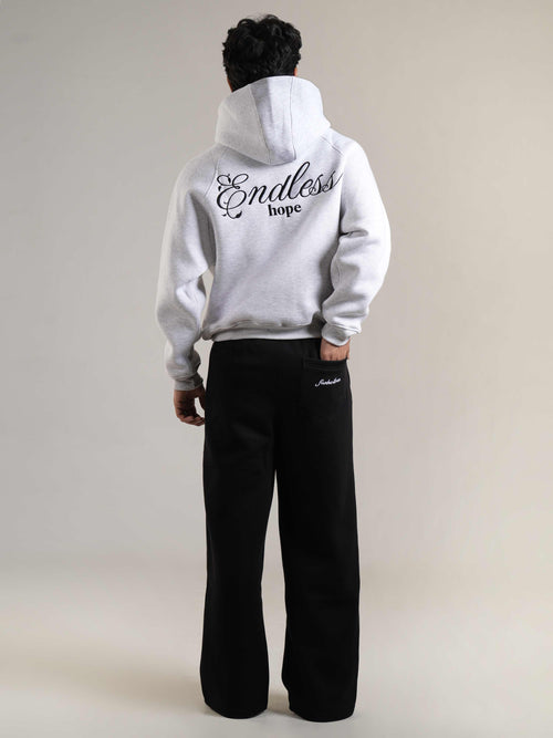 Person wearing a white hoodie with 'Endless hope' text on the back, standing against a plain background.