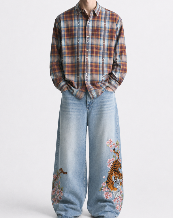 Person wearing a plaid shirt and jeans with tiger designs on a white background