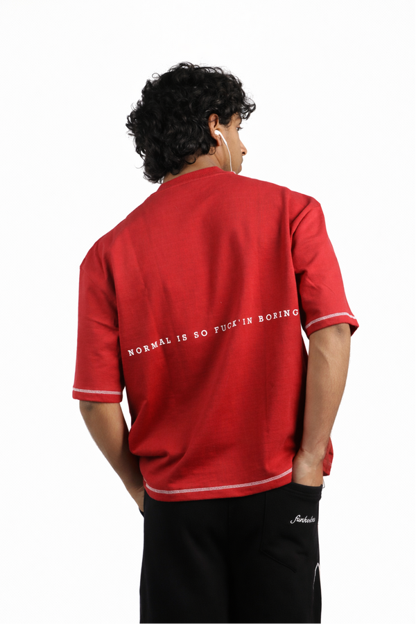 Person wearing a red shirt with text on the back, standing against a white background