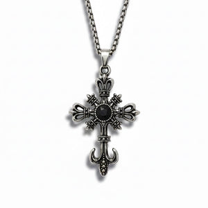Silver cross pendant with a black gemstone on a white background