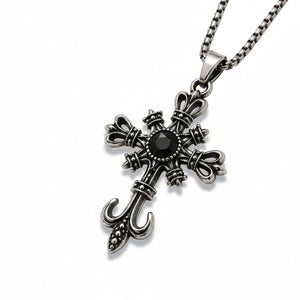 Silver cross pendant necklace with a black gemstone on a white background